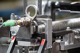 Feeding of cams in a defined position for the grinding process