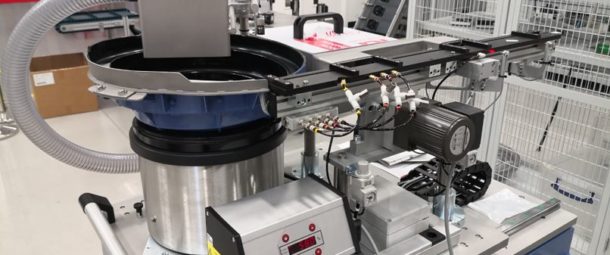 Vibratory bowl feeding and handling system feeds and orientates threaded inserts.